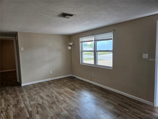 unfurnished room with a textured ceiling and dark wood-type flooring