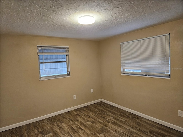 unfurnished room with dark hardwood / wood-style flooring and a textured ceiling