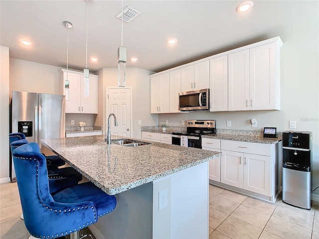 kitchen featuring sink, an island with sink, decorative light fixtures, white cabinetry, and stainless steel appliances