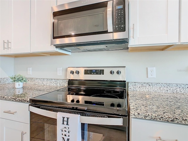 kitchen featuring light stone countertops, appliances with stainless steel finishes, and white cabinetry