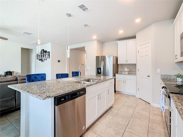 kitchen featuring appliances with stainless steel finishes, a center island with sink, white cabinetry, and sink