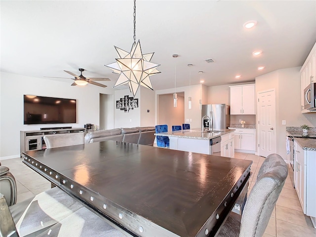 dining area with ceiling fan, sink, and light tile patterned floors