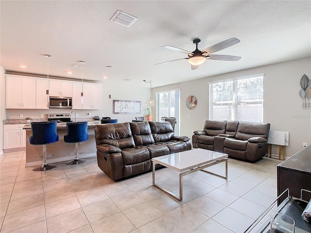 tiled living room with ceiling fan