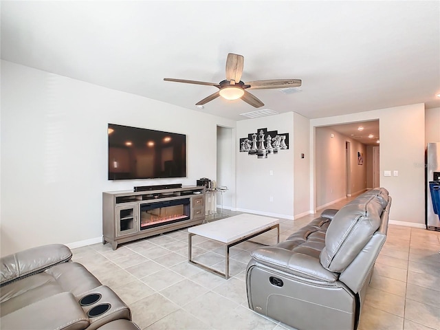 tiled living room featuring a fireplace and ceiling fan