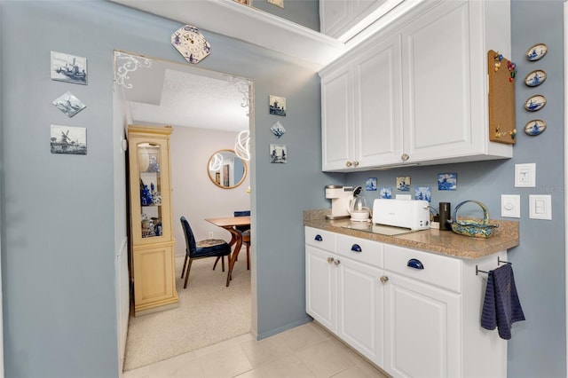 kitchen featuring a textured ceiling, white cabinetry, and light tile patterned flooring