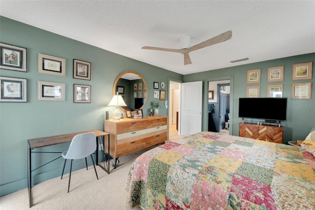 carpeted bedroom featuring ceiling fan and a textured ceiling