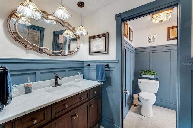 bathroom featuring vanity, toilet, and a textured ceiling