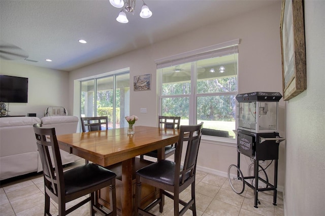 tiled dining area featuring a textured ceiling and an inviting chandelier