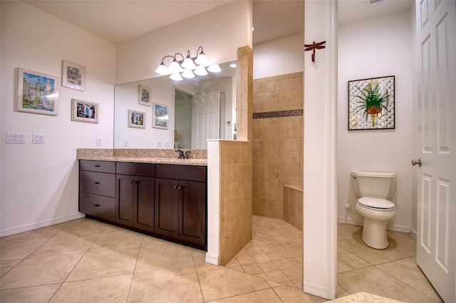 bathroom featuring tile patterned flooring, a tile shower, vanity, and toilet