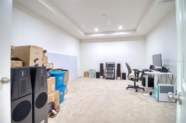 office with a tray ceiling and carpet flooring