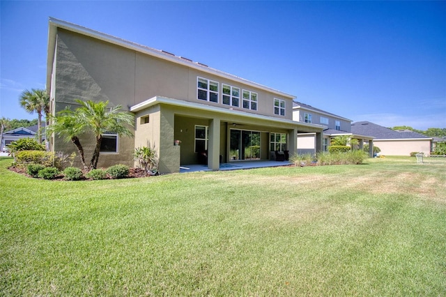 rear view of property featuring a lawn and a patio area