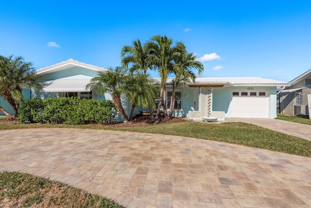 ranch-style home featuring a front lawn and a garage