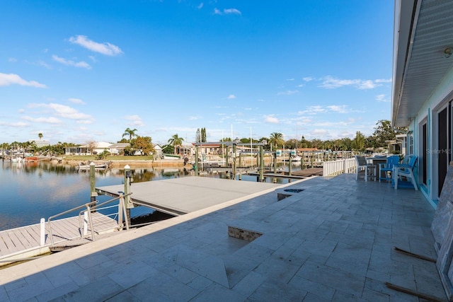 view of patio featuring a water view and a dock