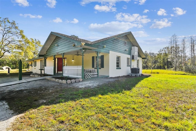 exterior space with covered porch, ceiling fan, cooling unit, and a lawn