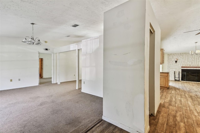 interior space featuring a textured ceiling, dark hardwood / wood-style flooring, and ceiling fan with notable chandelier