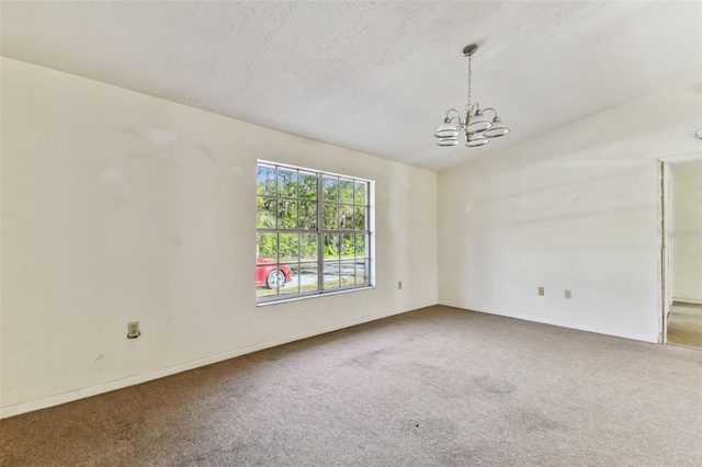 empty room featuring carpet floors and an inviting chandelier