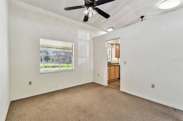 unfurnished room featuring carpet, ceiling fan, and vaulted ceiling