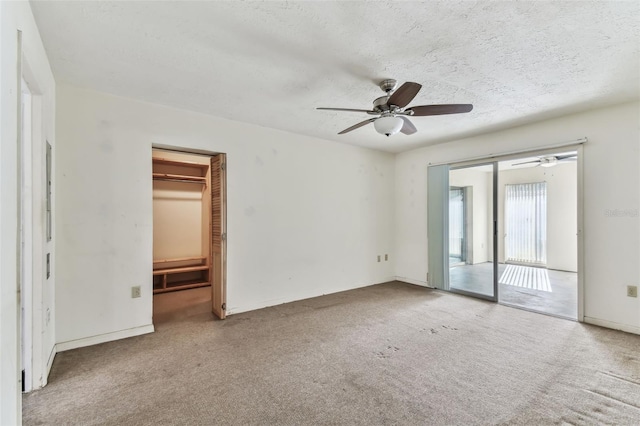 empty room with carpet flooring, ceiling fan, and a textured ceiling