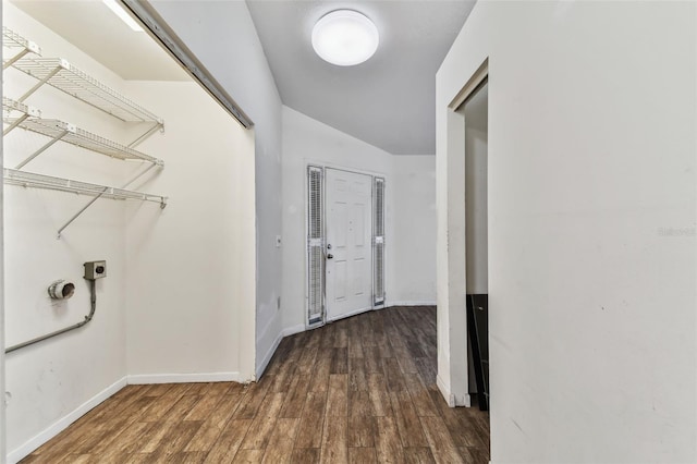 hall featuring lofted ceiling and dark hardwood / wood-style floors