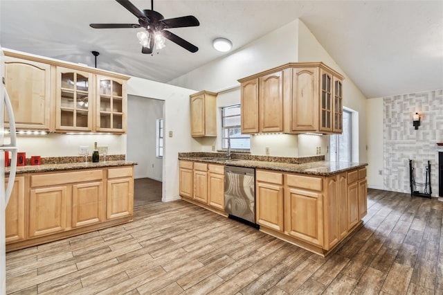 kitchen with dishwasher, light brown cabinetry, light hardwood / wood-style floors, and dark stone countertops