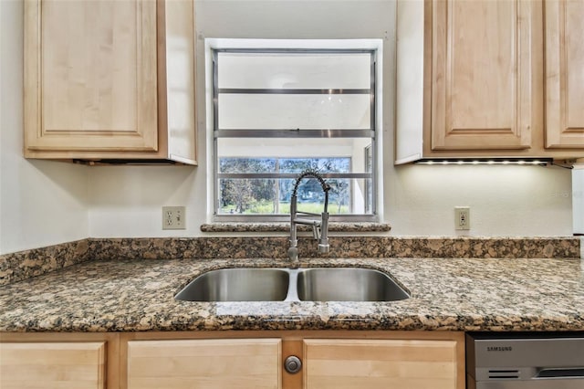 kitchen with light brown cabinetry, dishwasher, sink, and dark stone counters