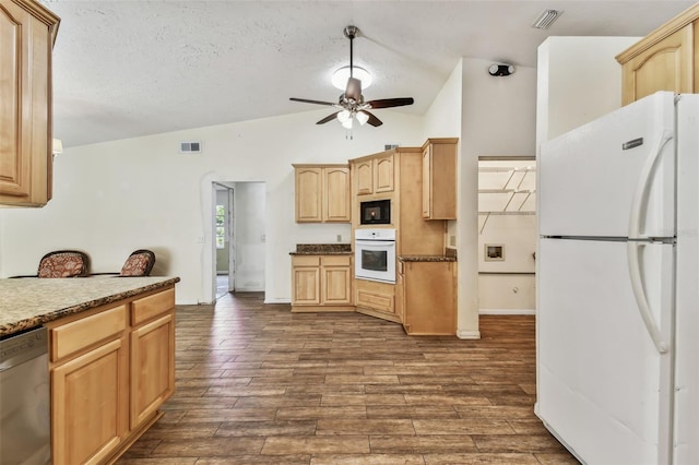 kitchen featuring light brown cabinets, white appliances, vaulted ceiling, ceiling fan, and a textured ceiling