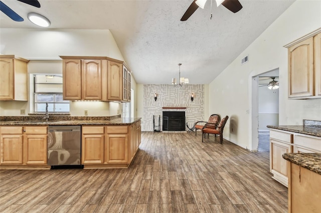 kitchen with pendant lighting, dishwasher, a fireplace, and hardwood / wood-style floors