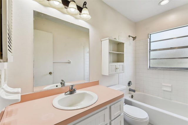 full bathroom with vanity, tiled shower / bath combo, and toilet