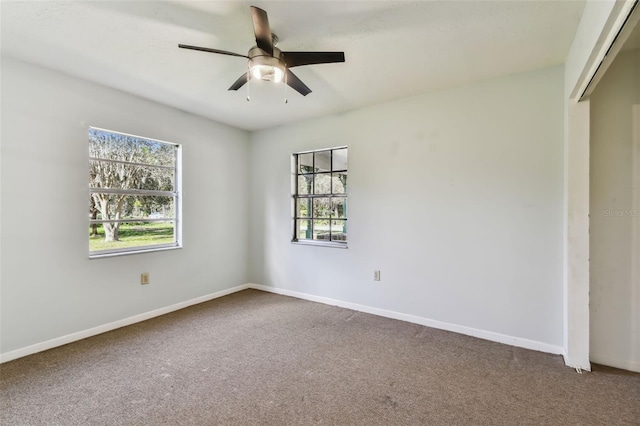 carpeted spare room with ceiling fan