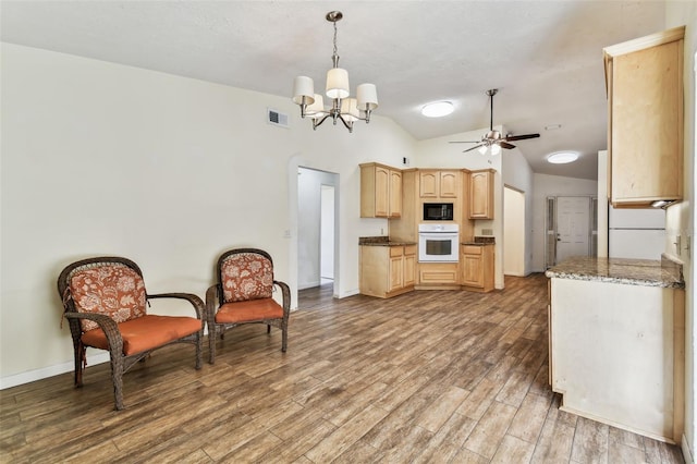 kitchen featuring black microwave, oven, pendant lighting, wood-type flooring, and light brown cabinetry