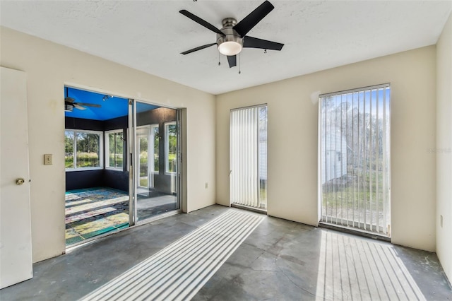 interior space featuring ceiling fan and concrete floors