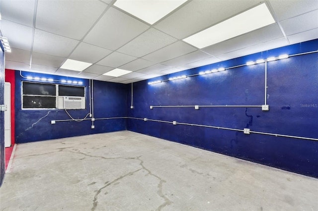 interior space with a paneled ceiling and concrete floors