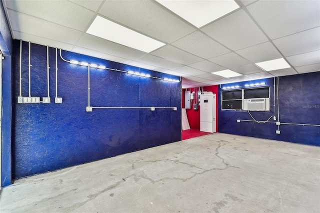 interior space featuring a paneled ceiling, electric panel, and concrete floors