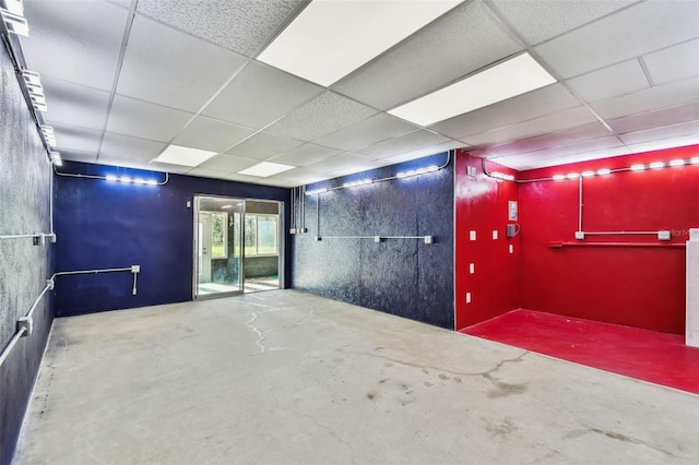 unfurnished room featuring a paneled ceiling and concrete floors