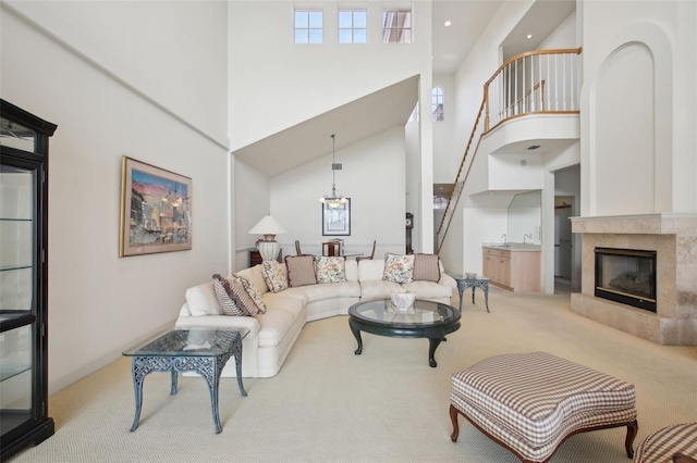 carpeted living room featuring a fireplace and a towering ceiling