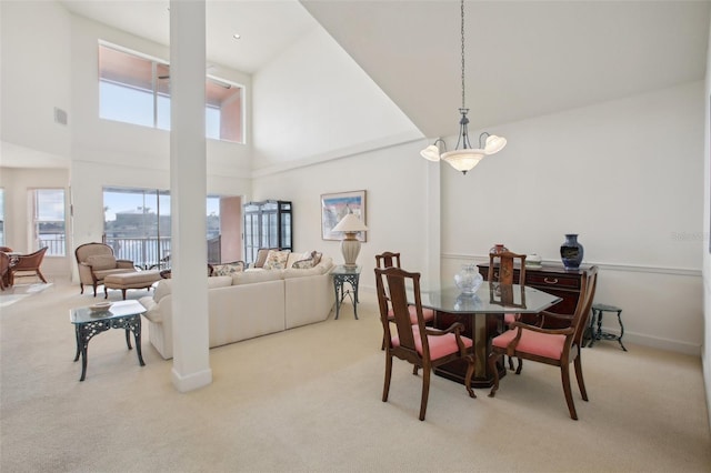 carpeted dining room featuring a towering ceiling