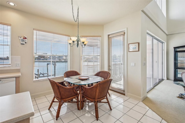 dining space featuring light carpet and a notable chandelier