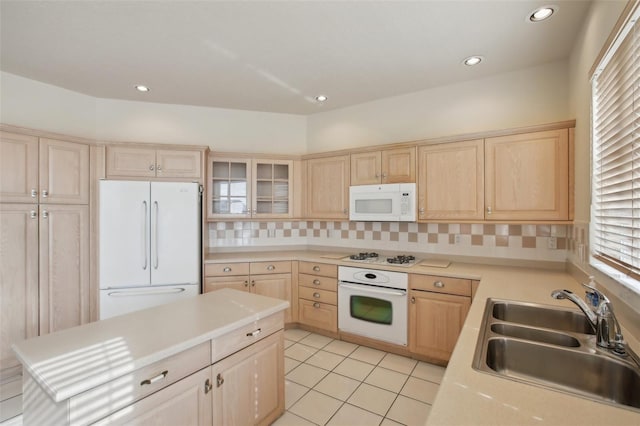 kitchen with light brown cabinets, light tile patterned flooring, white appliances, sink, and a healthy amount of sunlight