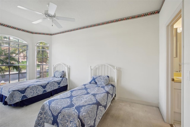 bedroom featuring ensuite bath, ceiling fan, and light carpet