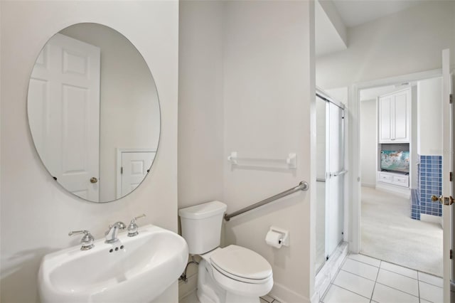 bathroom with tile patterned floors, sink, walk in shower, and toilet