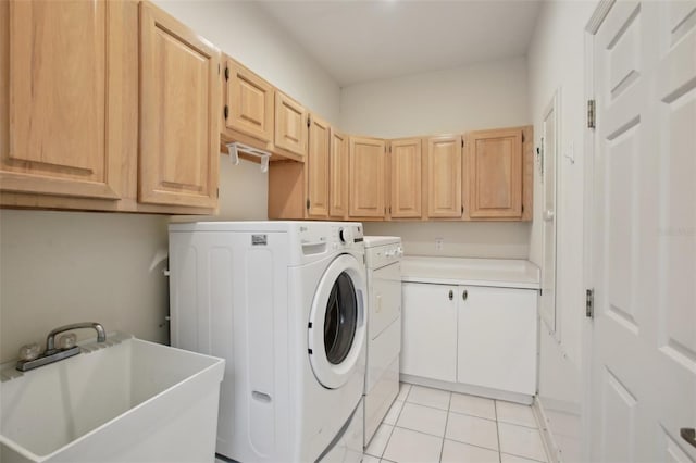 washroom with washing machine and clothes dryer, sink, light tile patterned flooring, and cabinets