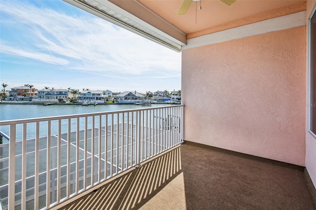 balcony featuring a water view and ceiling fan