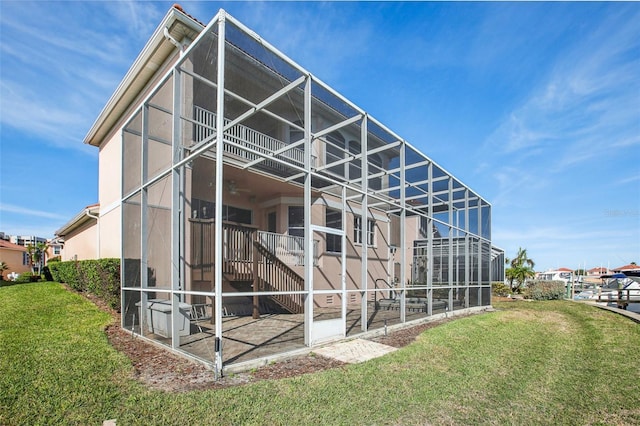 exterior space featuring a lawn and glass enclosure