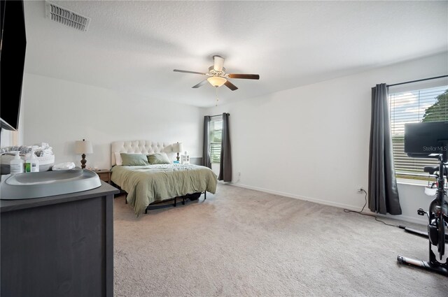 bedroom featuring ceiling fan, carpet, and a textured ceiling