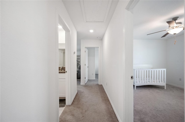 hallway featuring light colored carpet