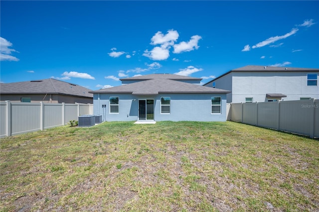 back of property featuring a lawn and cooling unit