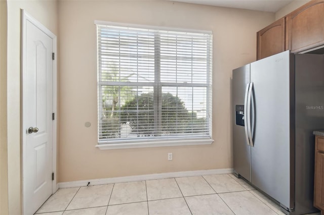 kitchen featuring stainless steel refrigerator with ice dispenser, plenty of natural light, and light tile patterned floors