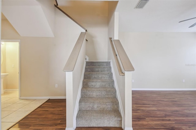 stairs with hardwood / wood-style flooring and ceiling fan