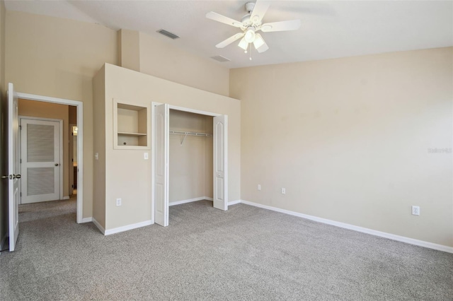 unfurnished bedroom featuring vaulted ceiling, light colored carpet, ceiling fan, and a closet