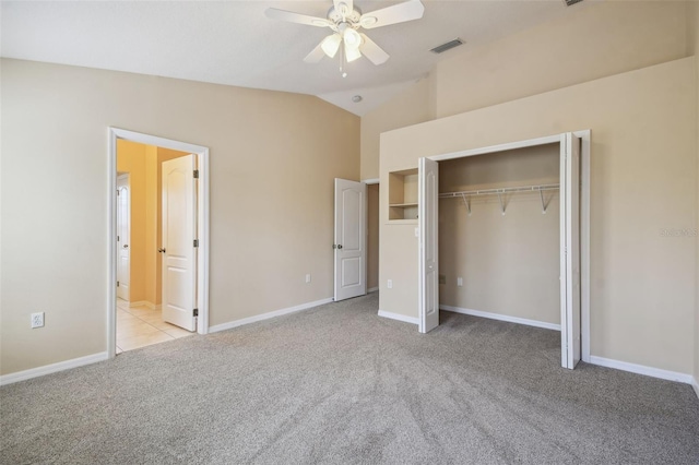 unfurnished bedroom with ensuite bath, ceiling fan, light carpet, vaulted ceiling, and a closet